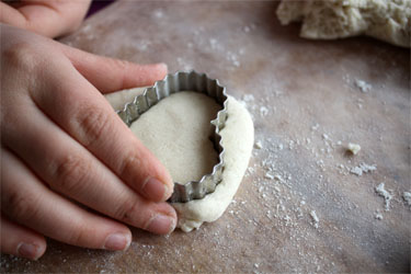 girl's hand making heart shape with salt dough
