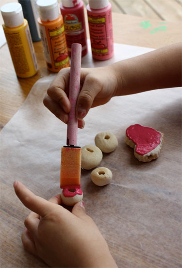 girl's hands painting salt dough beads 