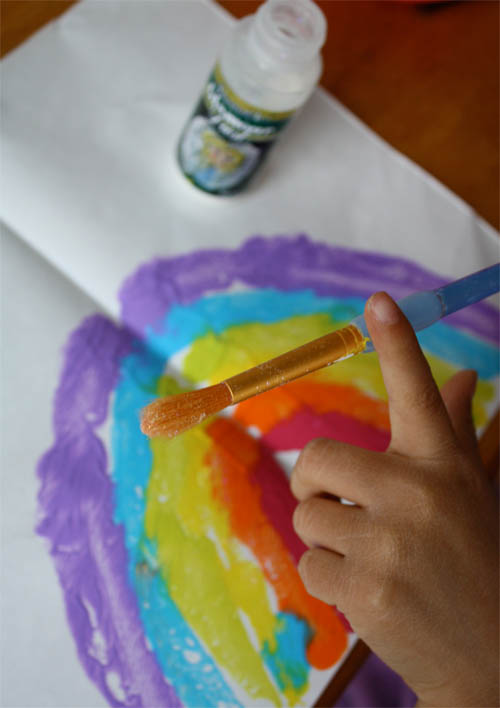 glitter dust on paintbrush, rainbow painting on table 