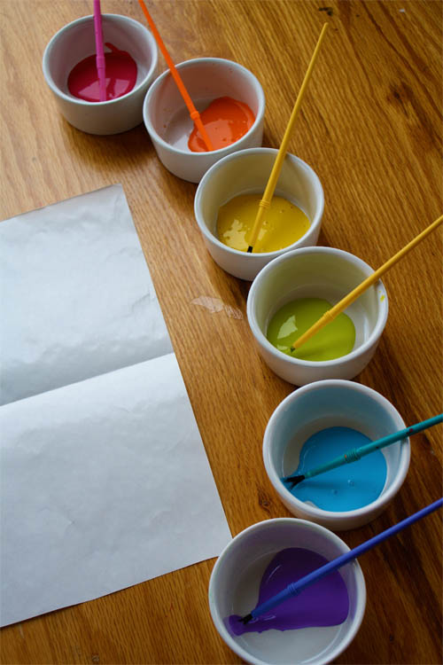 small bowls filled with paint and paintbrushes 