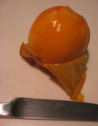 Peach part way peeled after being in ice bath.