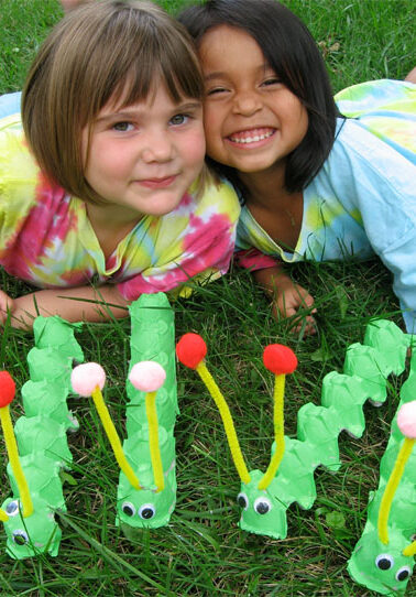 two little girls with egg carton caterpillars they made