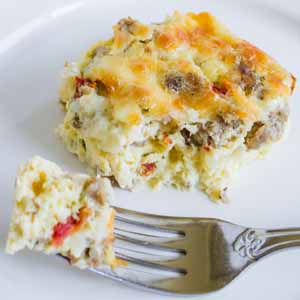 egg breakfast casserole with fork on white plate