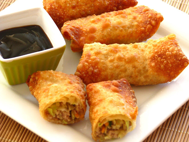 IMG_8473 Pan fried and air fried home made egg rolls served with dipping sauce on a a white plate.
