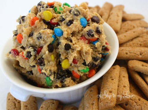 cookie dough dip in a white bowl with graham sticks along the side
