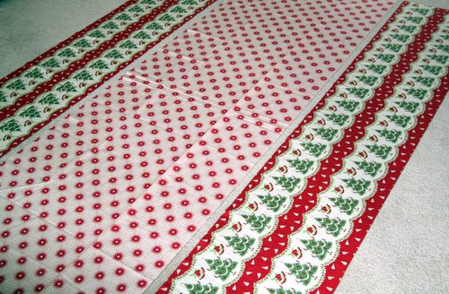 Completed tablecloth following the Holiday Tablecloth Tutorial with vintage Christmas fabric with bells, trees, and stars in red, green, and white. -Skip To My Lou