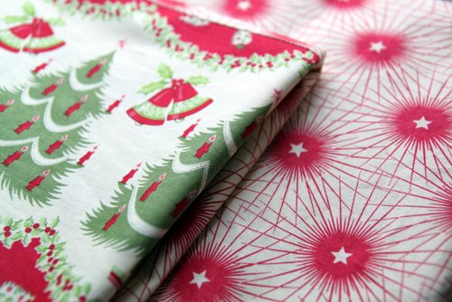 Folded Holiday Table Cloth showing details of vintage fabric with bursts of stars, Christmas trees, and bells. -Skip To my Lou