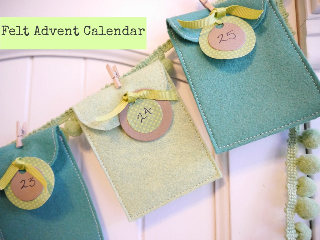 Felt Advent Calendar felt pockets in pastel teal colors are held on a ribbon with a tiny clothes pin. -Skip To My Lou