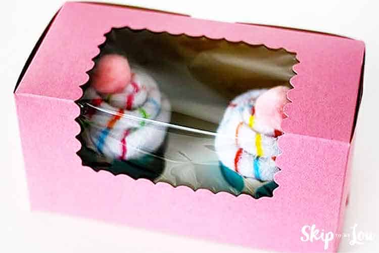 two sock cupcakes in a pink bakery box