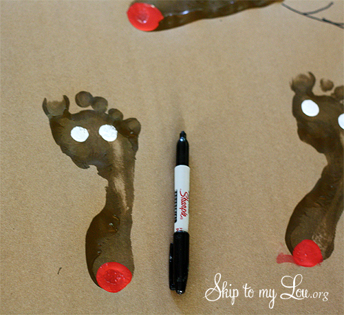 DIY Wrapping Paper Tutorial Step 4 eyes are added to the footprints with a round sponge brush and white paint; once dried black pupils are added using the permanent marker