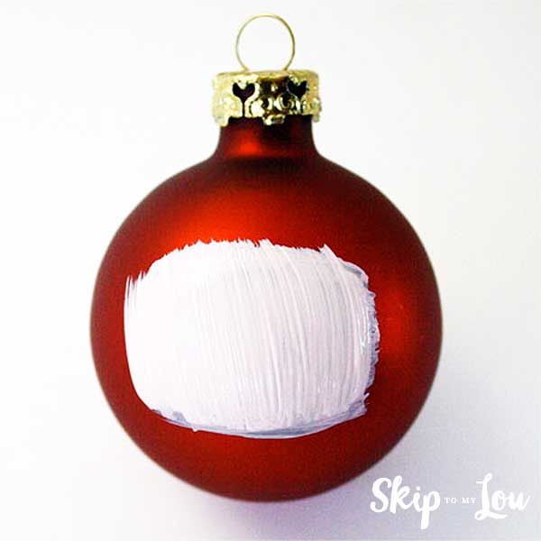 white rectangle painted on christmas ball start of santa face
