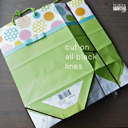 A gift bag with the bottom opened up and a black line down the side seam of the bag to be cut.