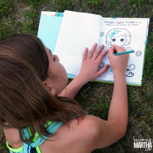 Young girl coloring in the gift bag coloring book.