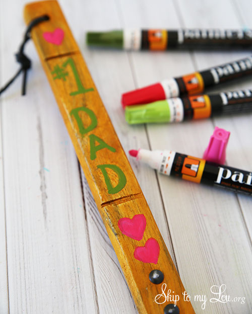 spatula with paint pens, number one dad was written in green and hearts drawn in pink on the handle