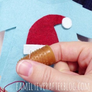 Getting ready to hand stitch the Santa hat to the light blue onsie.