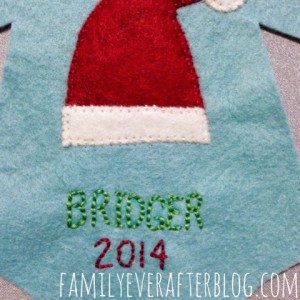 Santa hat, baby name, and year stitched on to the onesie felt ornament.
