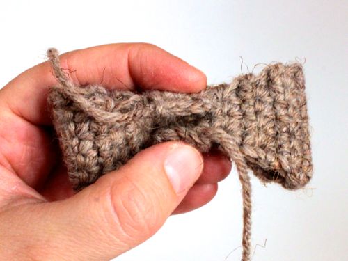 Step 3. Take the bow tie center, wrap it around the thinner part or the main bow tie and whipstitch the ends together