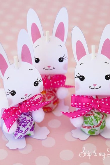 three bunny sucker holders sitting on a pink polka dot table covering