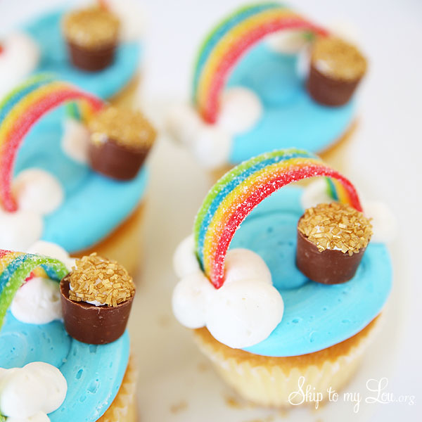 four completely decorated rainbow pot of gold cupcakes