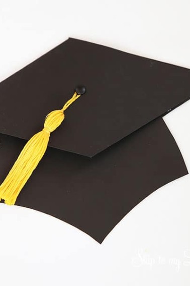 black grad hat with yellow tassel holds gift card
