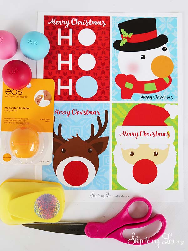Four EOS Lip Balm Christmas Gifts pintables. A Ho, Ho, Ho , snowman, reindeer, and Santa card. Supplies for making the gifts EOS lip balm in package, hole punch, and scissors. -Skip To My Lou