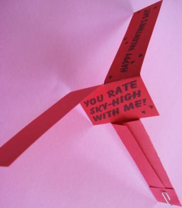 red whirly gig with a valentine message in black writing