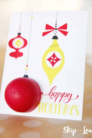 EOS lip balm happy holidays card with vintage red and gold ornaments and the lip balm inserted as a round ornament.