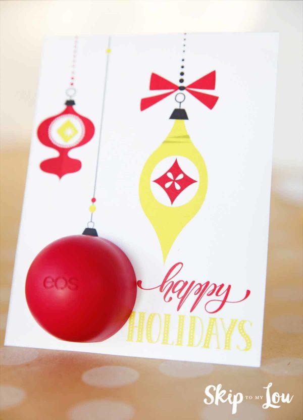 EOS lip balm happy holidays card with vintage red and gold ornaments and the lip balm inserted as a round ornament.