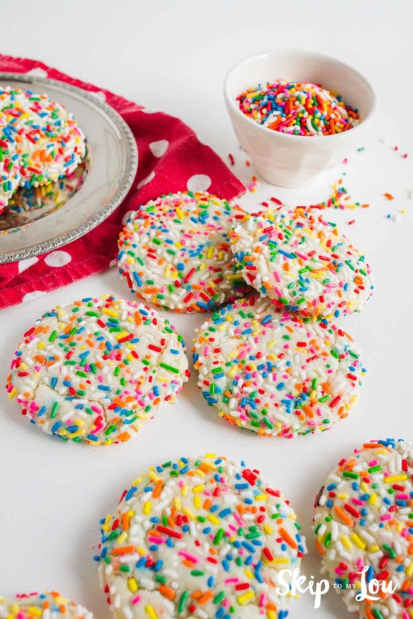 funfetti cookies on silver plater and white counter; there is also a small white bowl filled with multi-colored sprinkles