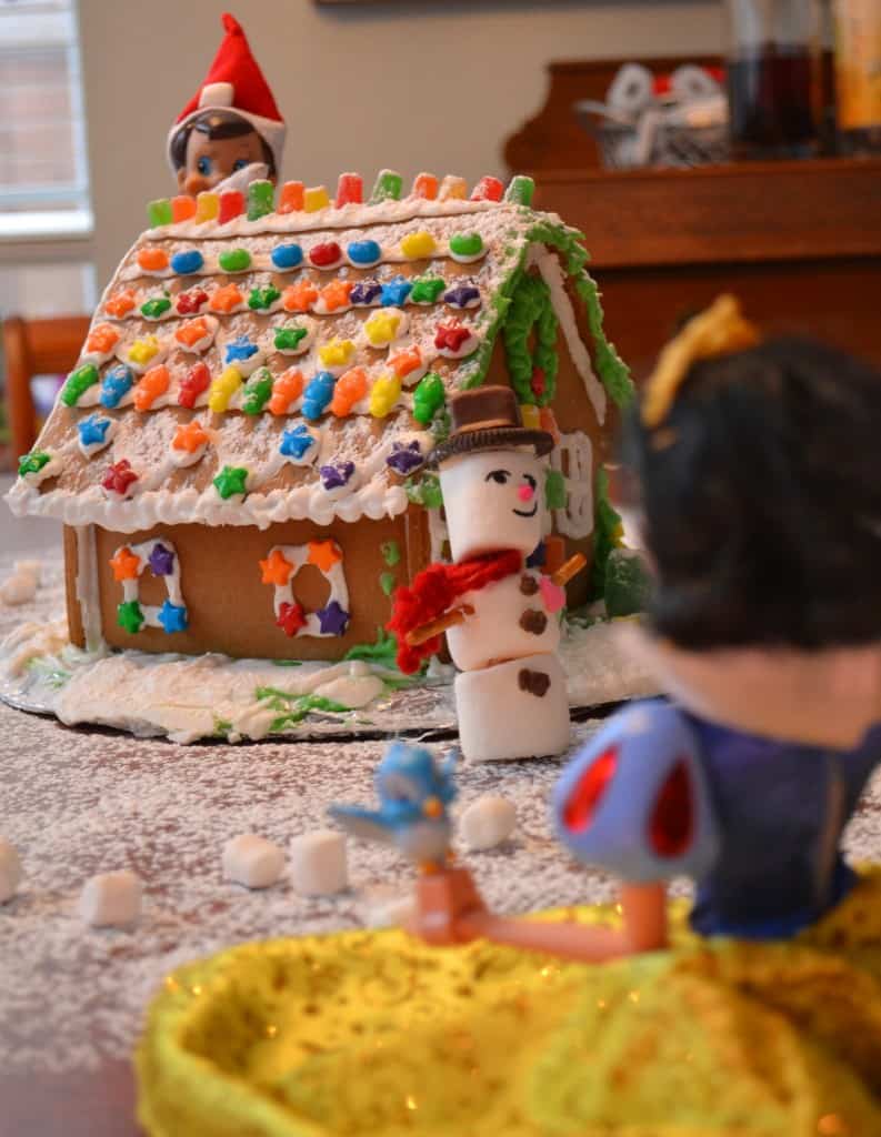 elf on shelf snowball fight with a ginger bread house and snow man blocking Cinderella's snowballs