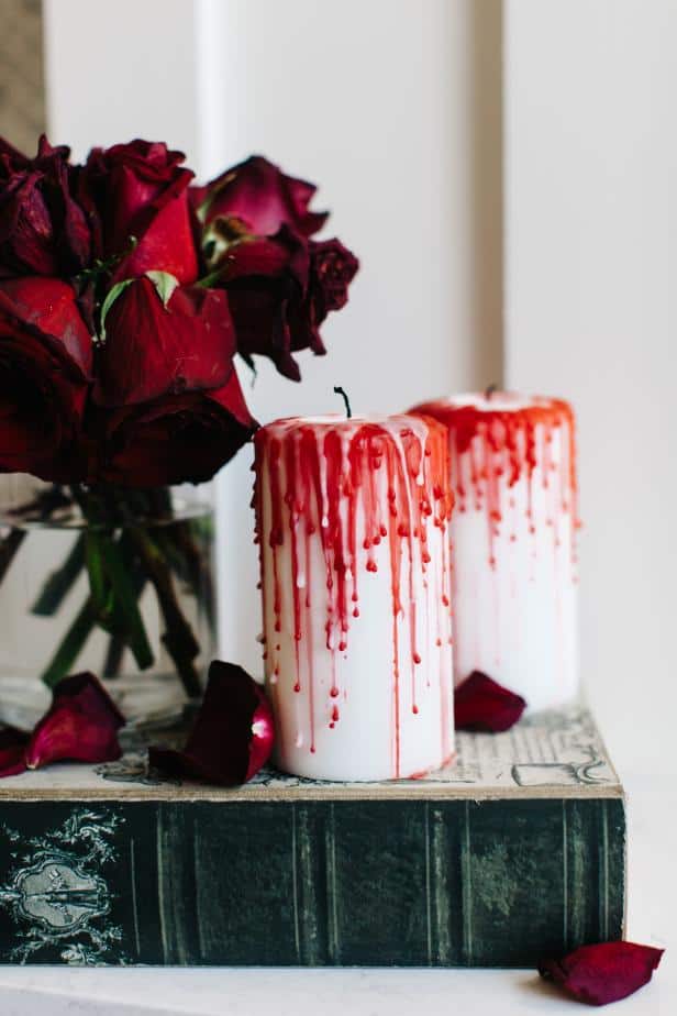 two bloody candles with dying red roses on a table top
