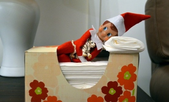 elf laying in a box of tissues with some folded to make a pillow
