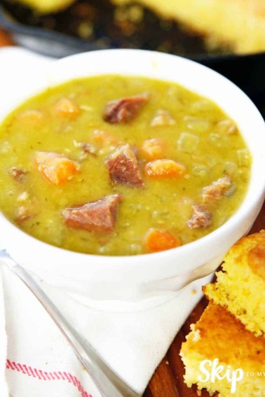 split pea soup in white bowl cornbread on side