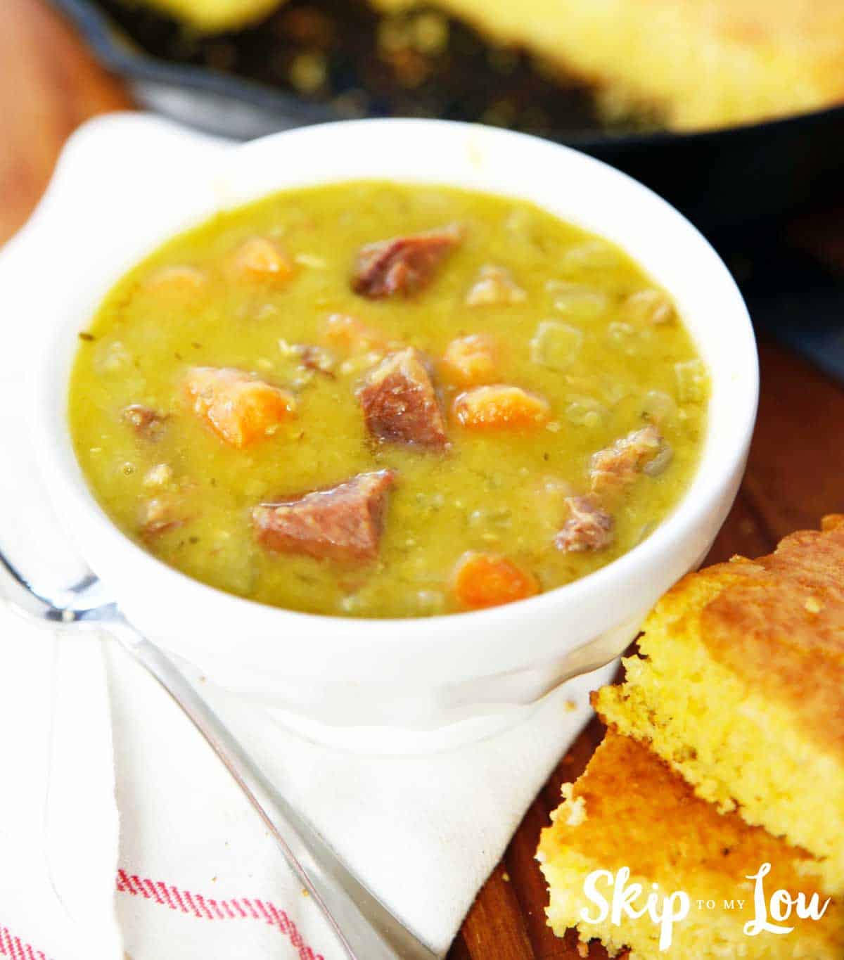split pea soup in white bowl cornbread on side