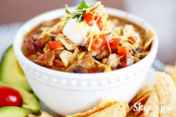 slow cooker chicken taco soup with avacado and tortilla chips on the side
