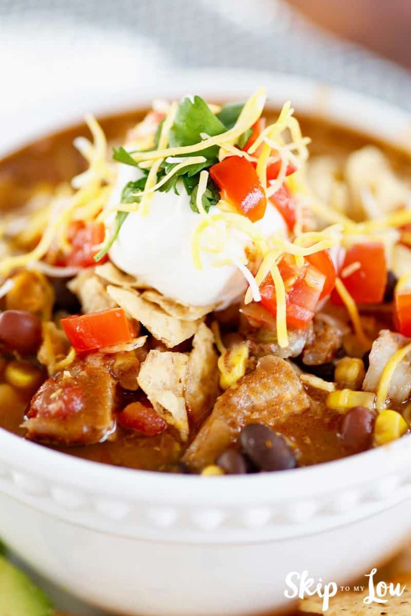 chicken taco soup topped with sour cream and tortilla chips