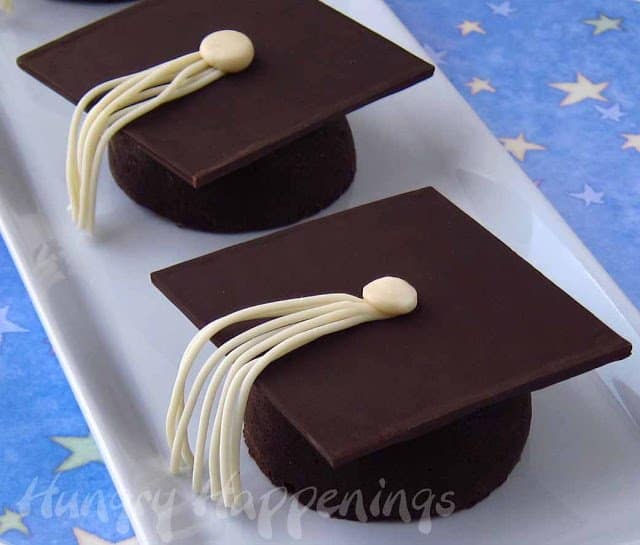 grad hat small cakes on white platter