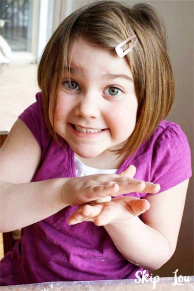 child rolling salt dough between hands