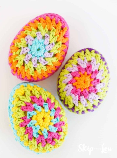 three crochet granny square pattern eggs on white background