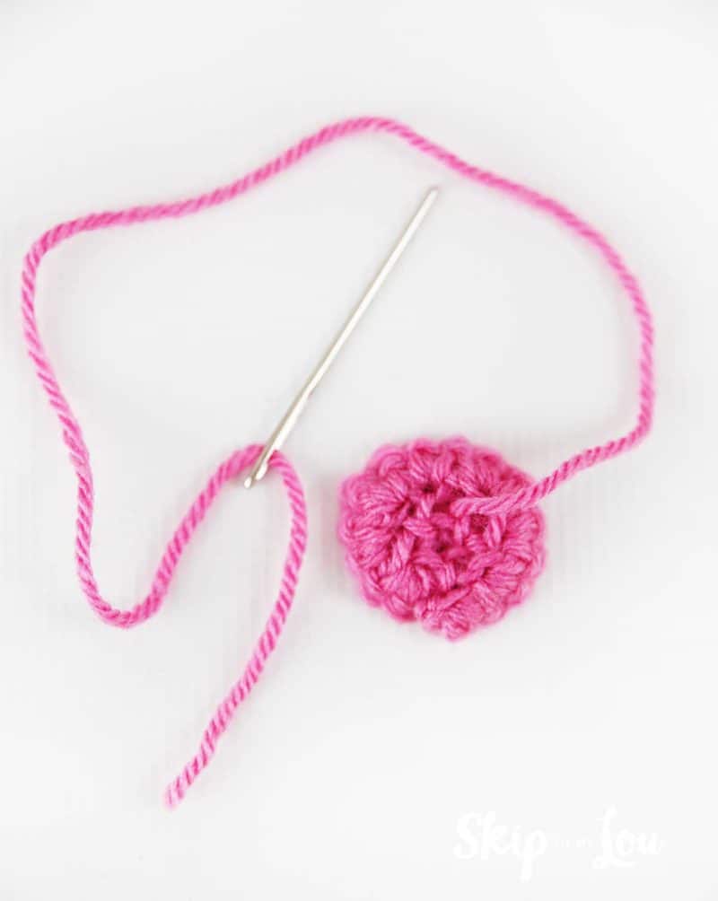 needle stitching back of crochet flower