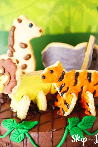 giraffe lion tiger and elephant cookies on cake