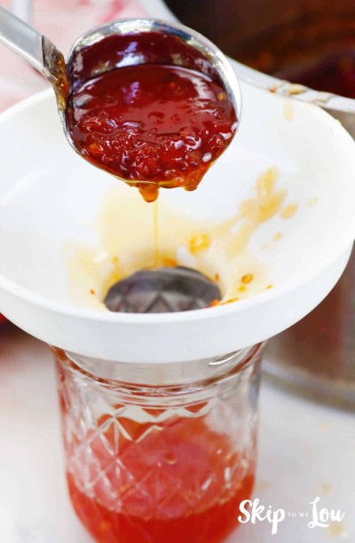 fill jars with hot pepper jelly using canning funnel