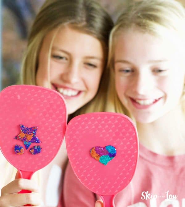 two girls holding glitter decorated hand held mirrors