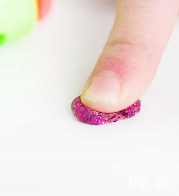 finger pressing Crayola glitter dot