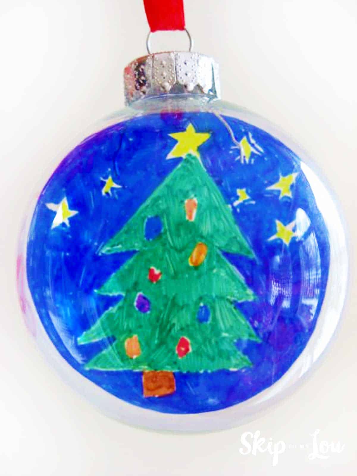 round glass ornament with childs artwork of christmas tree