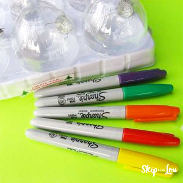 Clear glass ornament balls and blue, green, orange, red, and yellow sharpie markers for making glass Christmas ornament.