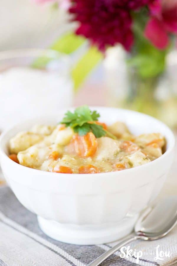 instant pot chicken and dumplings in white bowl flowers in background