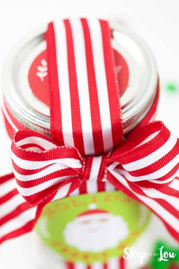 wrapped up holiday cookie in a jar with red and white ribbon