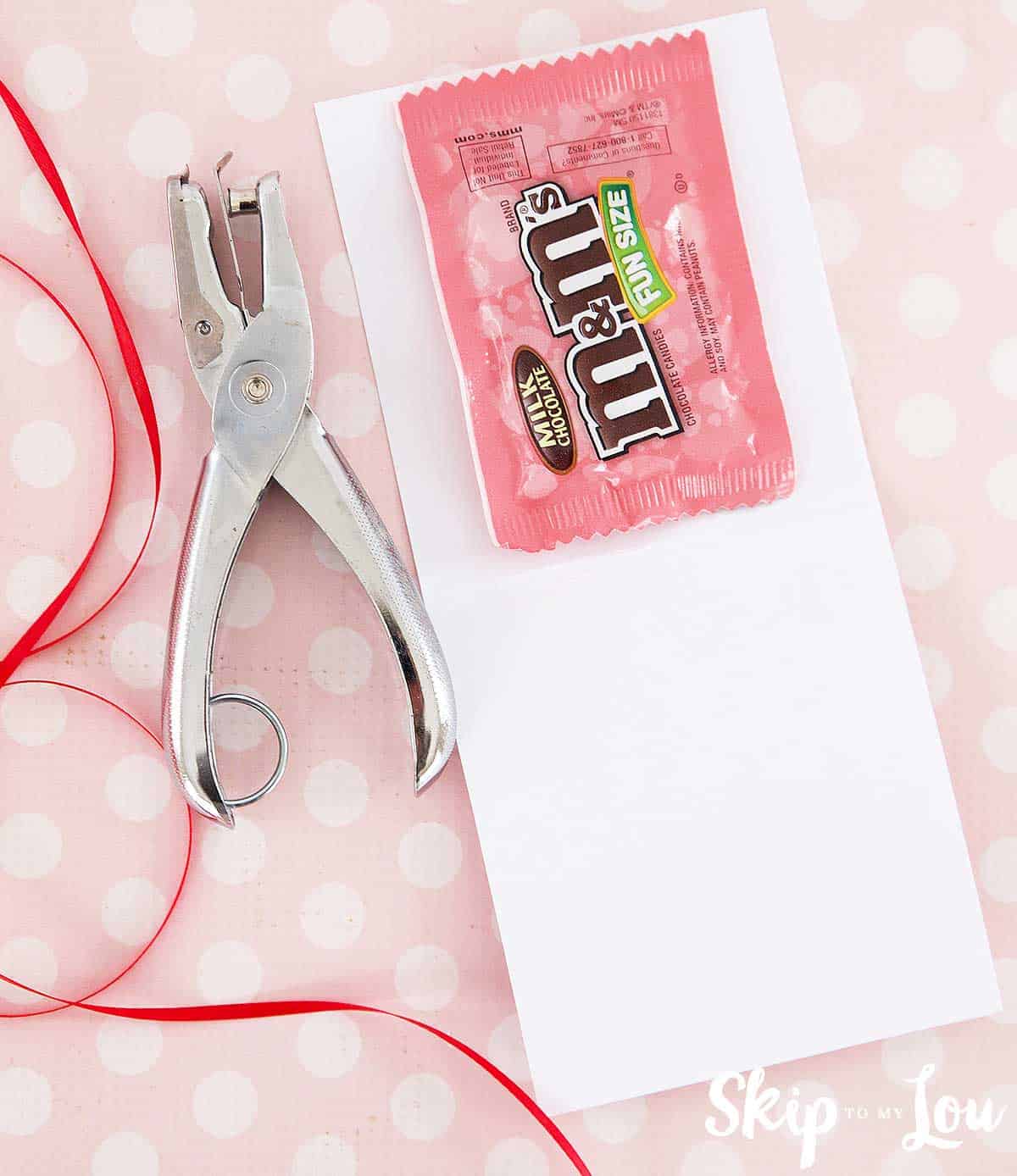 m&ms inside valentine with hole punch at side