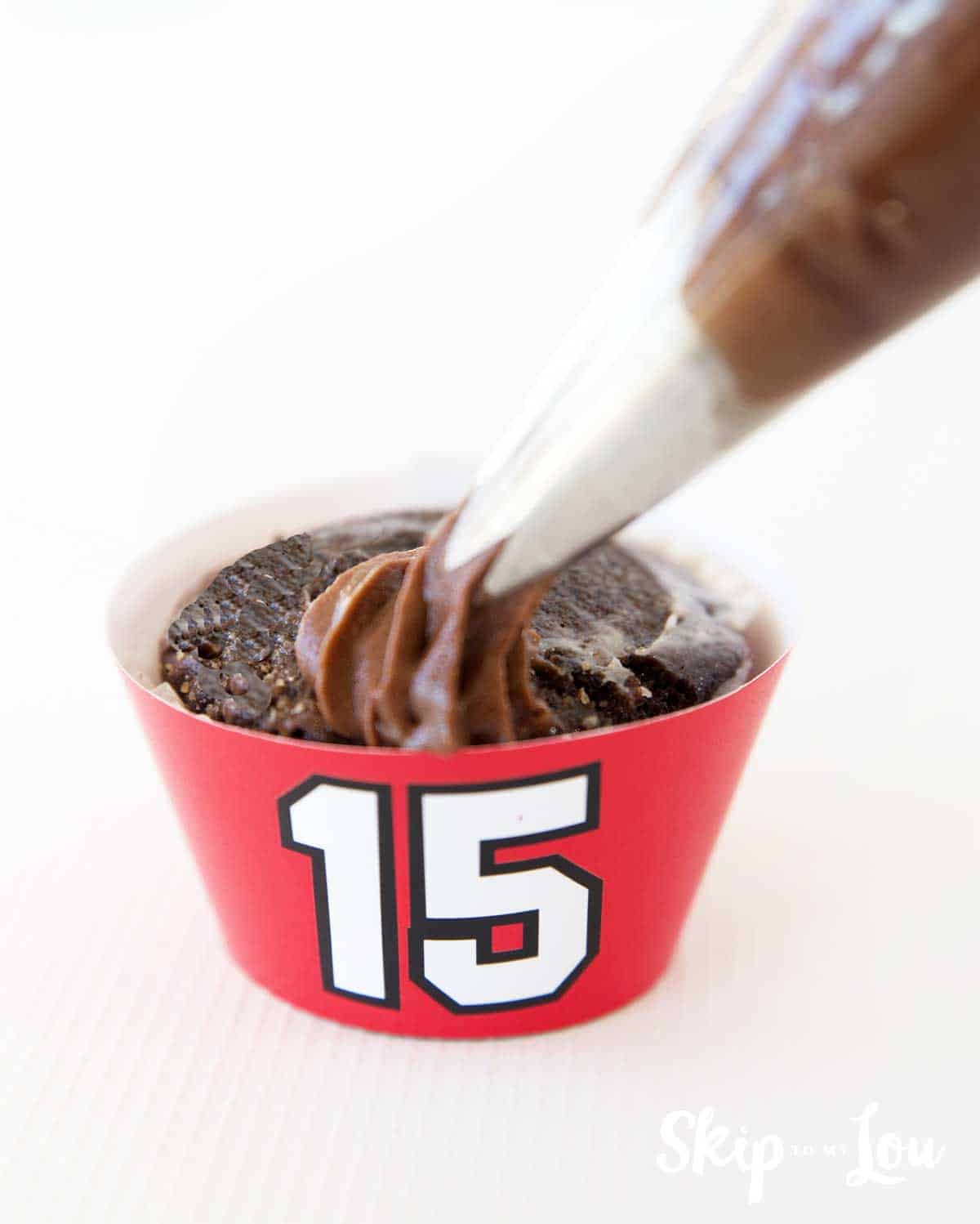 frosting cupcake with a Chiefs #15 cupcake wrapper